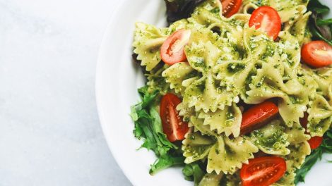 Piatto di pasta fredda con pesto e pomodorini