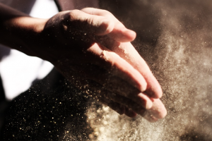 Un uomo unisce le mani sporche di farine