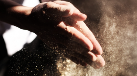 Un uomo unisce le mani sporche di farine