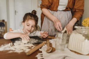 Una bimba e una mamma preparano taralli