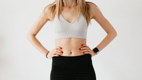 Una donna, in tenuta da ginnastica, tiene le mani sui fianchi