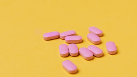 Pastiglie rosa su sfondo giallo