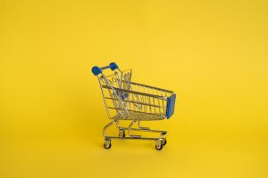 un carrello del supermercato su sfondo giallo