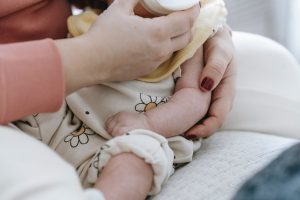 Una mamma allatta con biberon un neonato